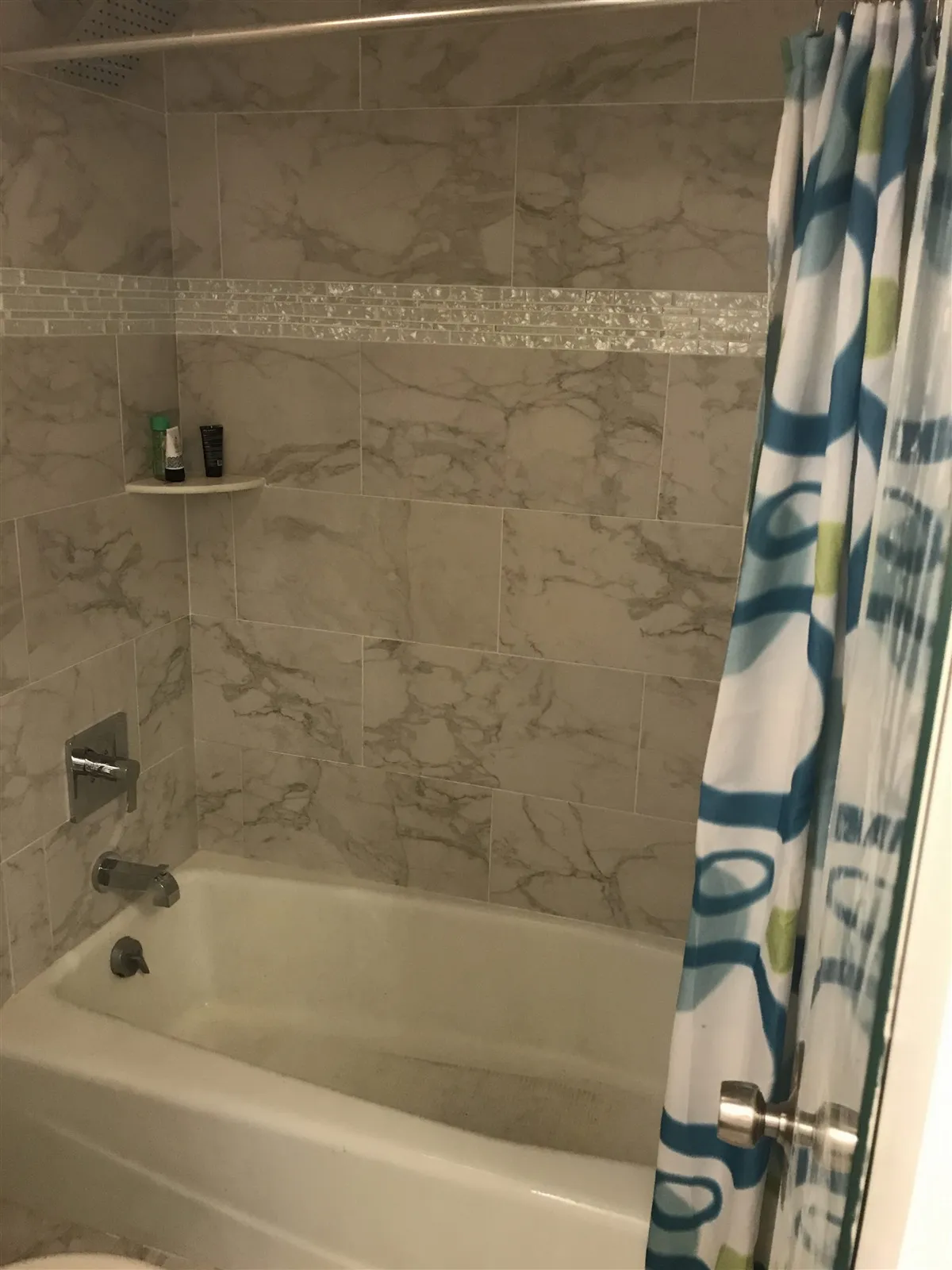 Tub and shower walls in large marble-look tile