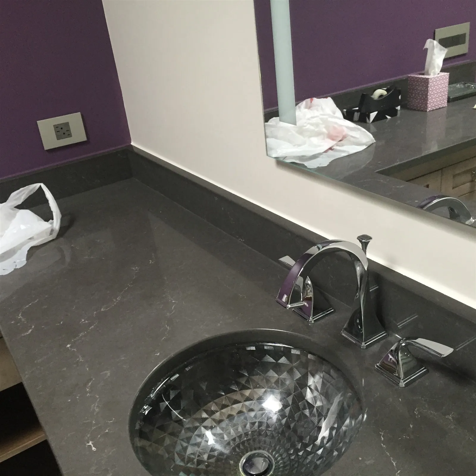 Stainless steel vessel sink on a dark stone counter