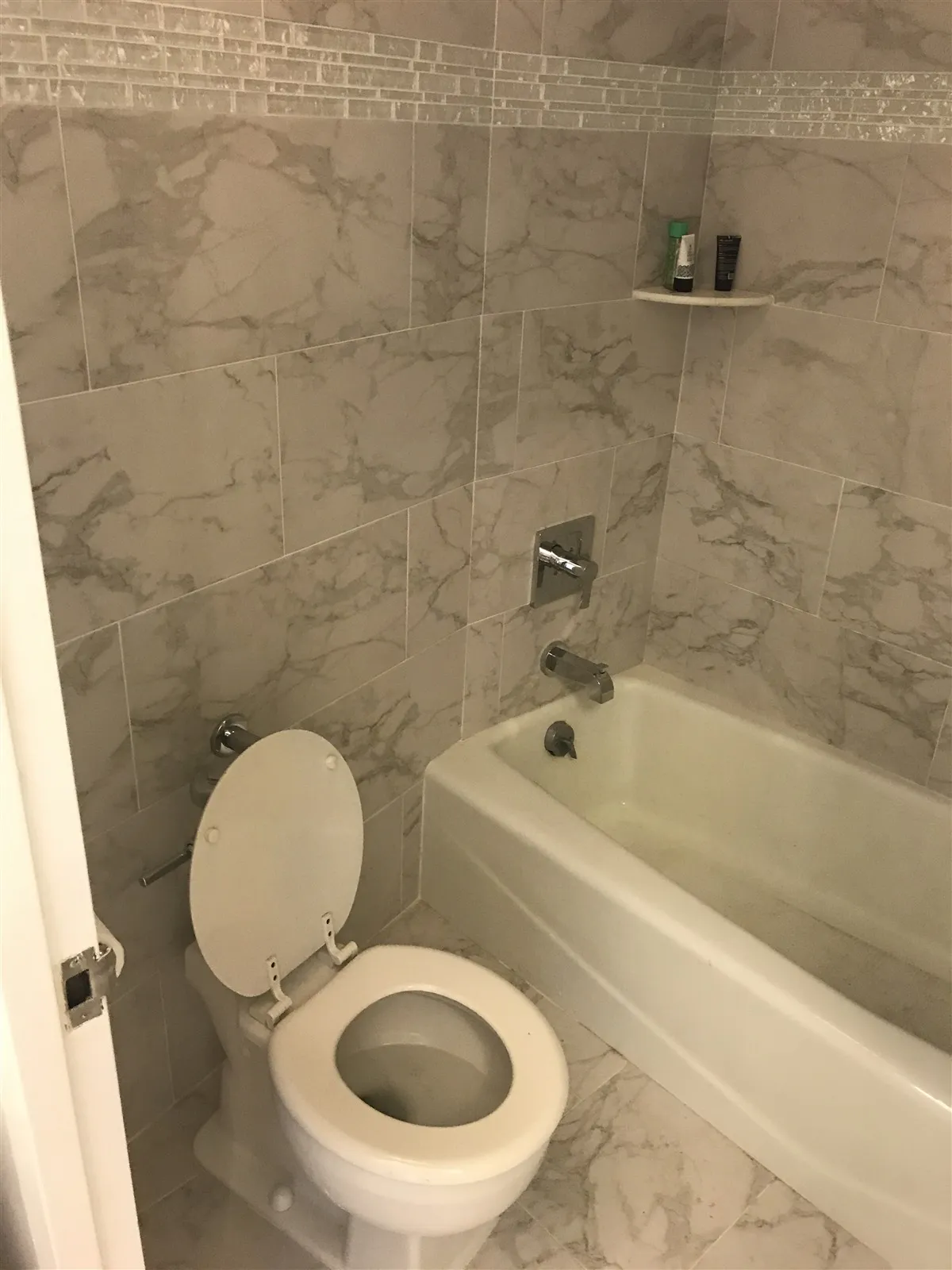 Remodeled tub and shower with large wall tile