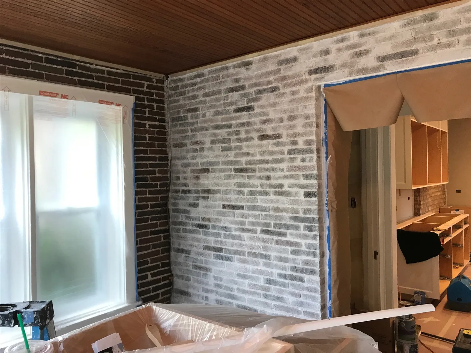 Finished room with exposed brick wall and wood ceiling