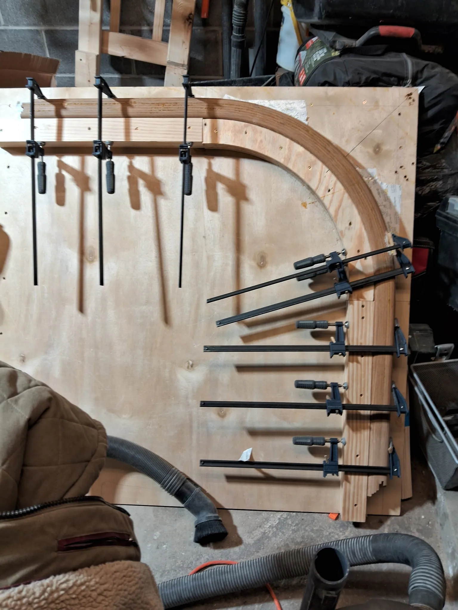 Quarter-turn curved oak handrail strips glued together on a plywood form