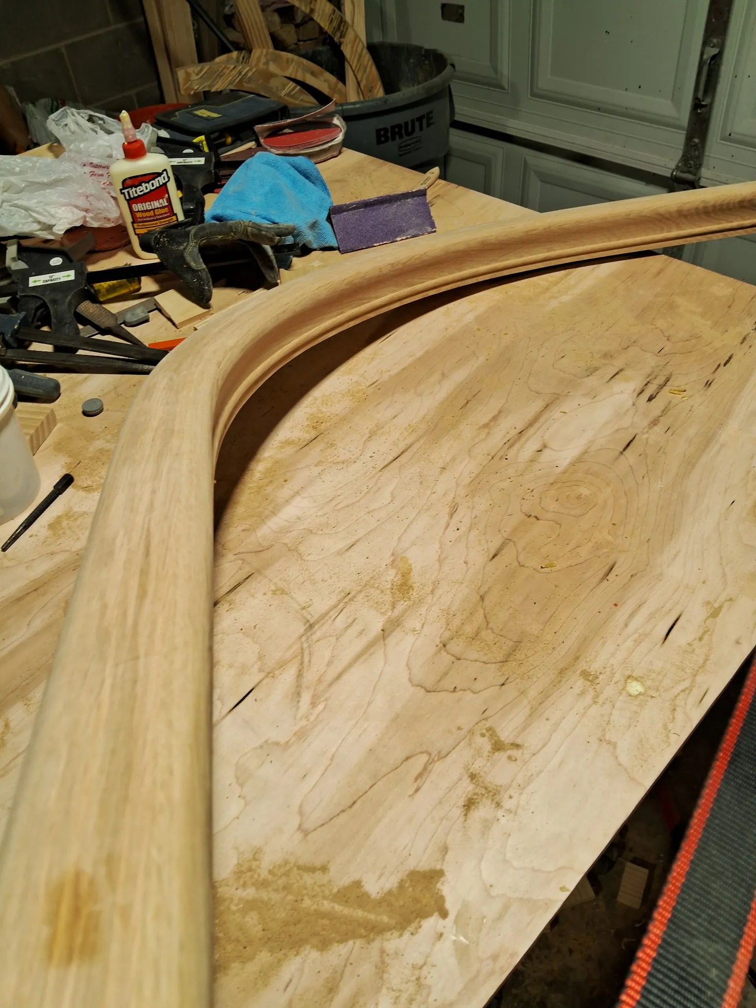 Smooth sanded curved oak handrail lying on a workbench after shaping