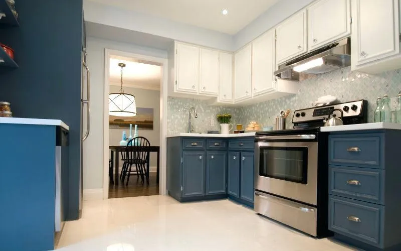 Kitchen with blue lower cabinets, white upper cabinets and stainless appliances