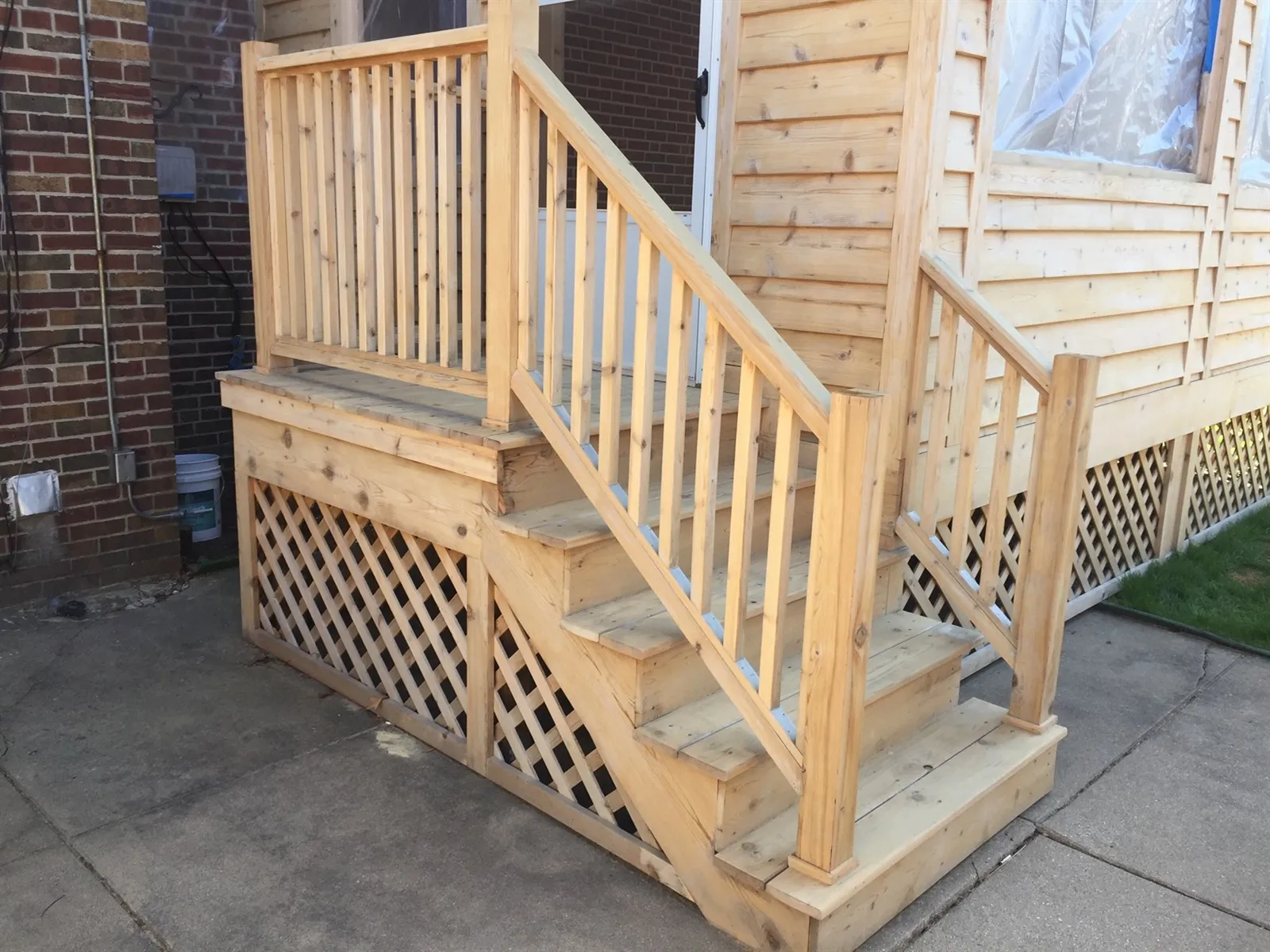 New wood porch stairs with railings and lattice