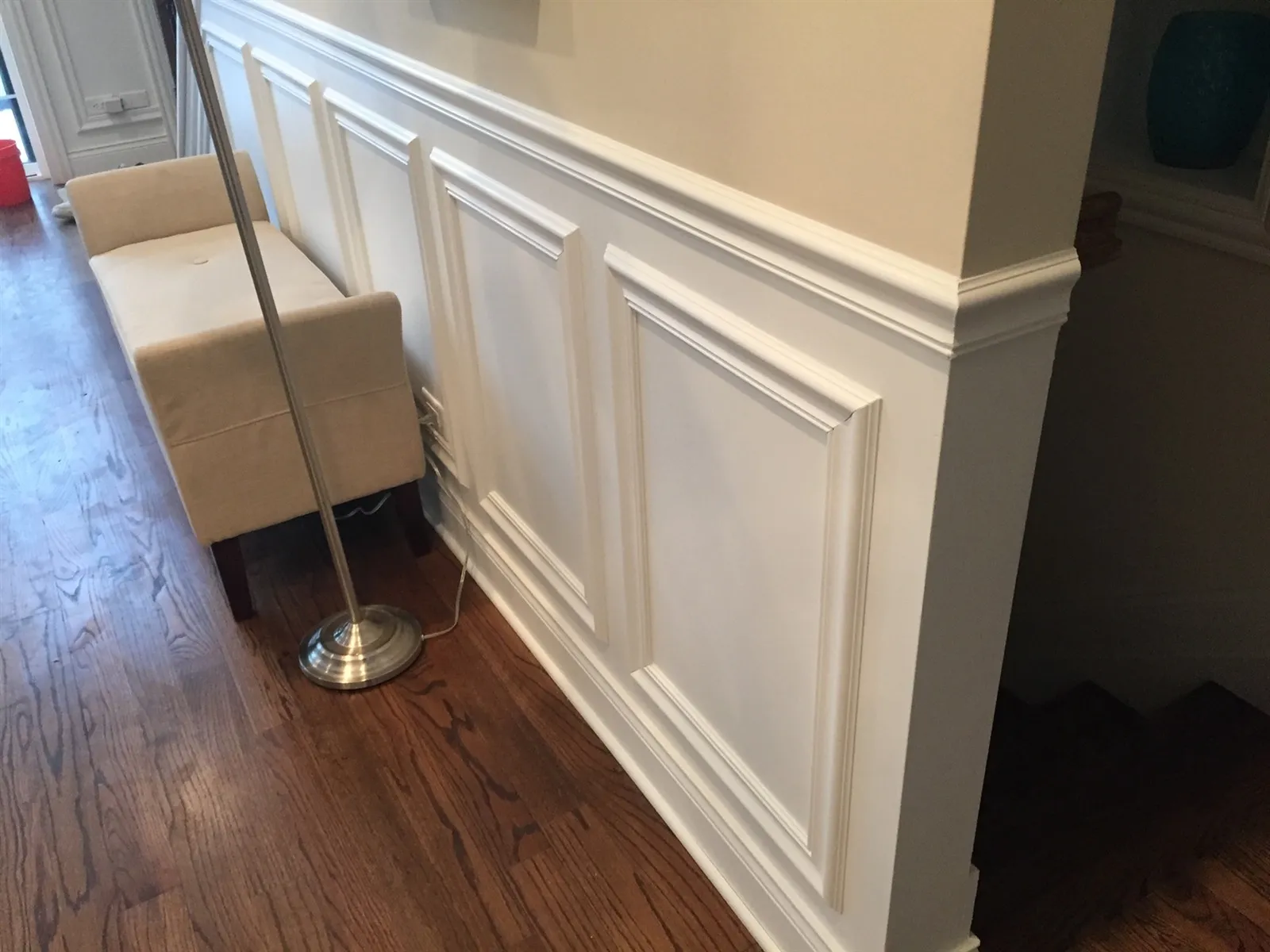 Hallway with white wainscoting panels and wood floor